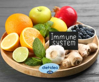 Piatto con agrumi, zenzero, aglio, menta, mela e mirtilli, alimenti ricchi di vitamine e antiossidanti utili a sostenere il sistema immunitario in inverno