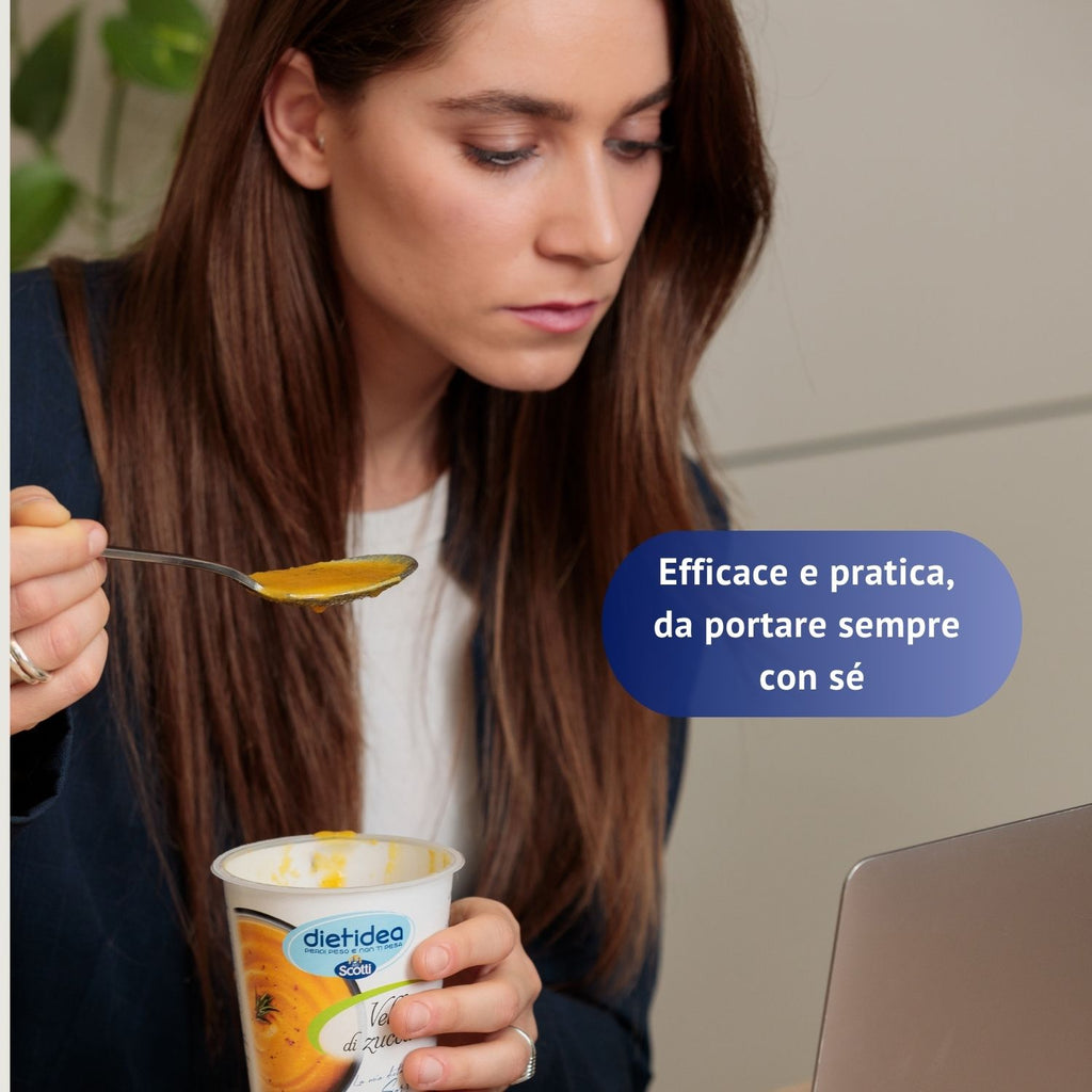 Immagine che mostra una ragazza che mangia una vellutata Dietidea al pc per dimostrare quanto è pratica la dieta da 7 giorni