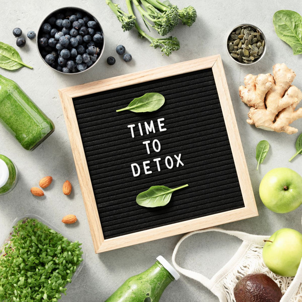 una lavagnetta con scritto TIME TO DETOX e intorno alcuni ingredienti deto come frutta e verdure a foglia verde 